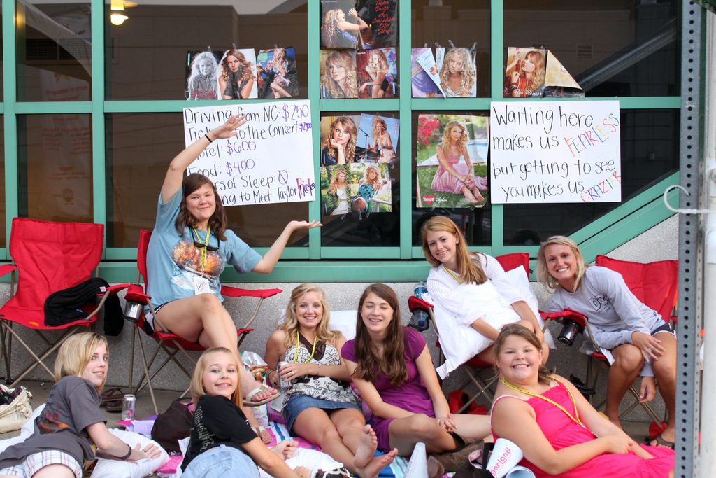 Young Taylor Swift fans waiting outside with her posters