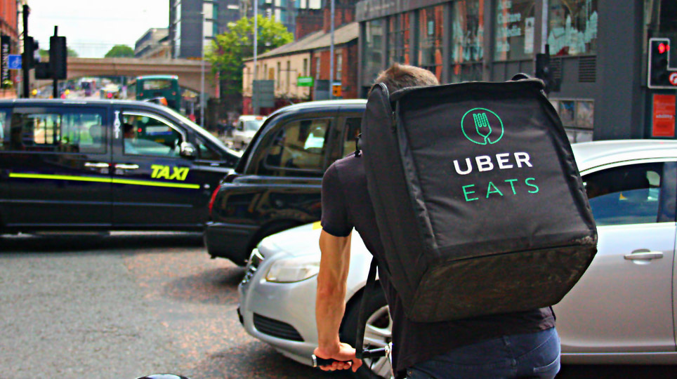 A UberEat delivery boy riding bicycle